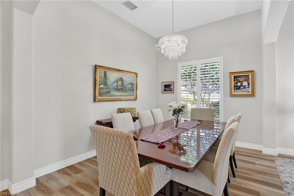 2065 Mandarin Lane Naples, FL 34120 - Photo 7 of 46 a view of a dining room with furniture a chandelier and wooden floor