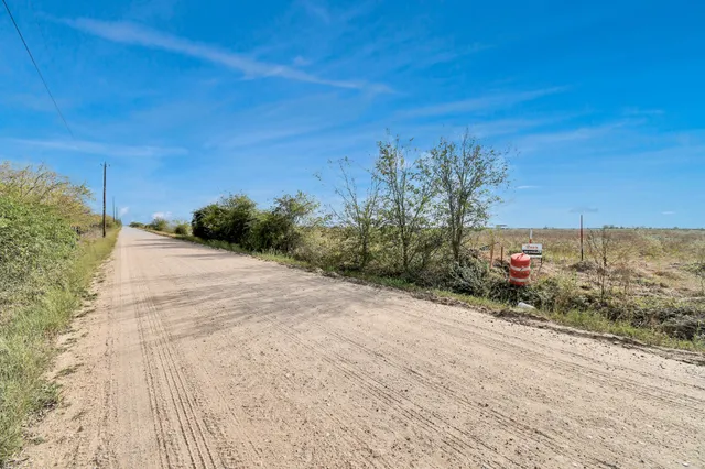 a view of dirt road with a building in the background