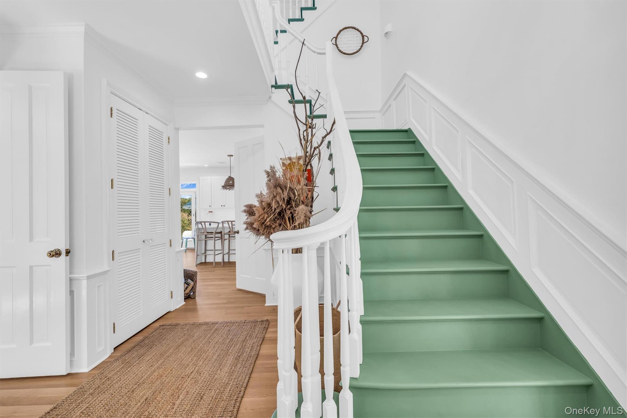 68 South Howells Point Road Bellport, NY 11713 - Photo 6 of 47 Grand staircase featuring white balusters and a curved handrail