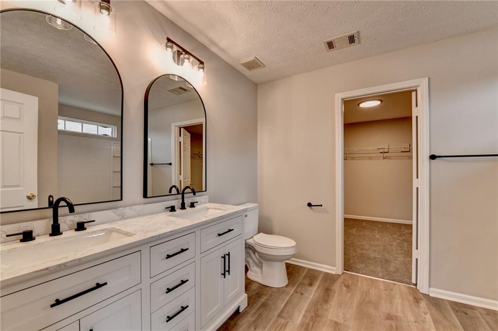 2748 Farmstead Court Grayson, GA 30017 - Photo 22 of 83 a bathroom with a double vanity sink a toilet and a mirror