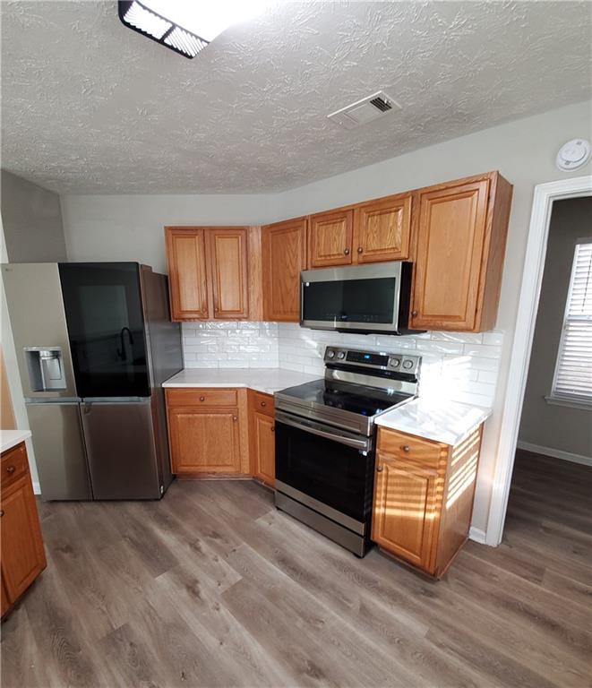 2748 Farmstead Court Grayson, GA 30017 - Photo 34 of 83 a kitchen with stainless steel appliances wooden cabinets a stove top oven a sink and dishwasher