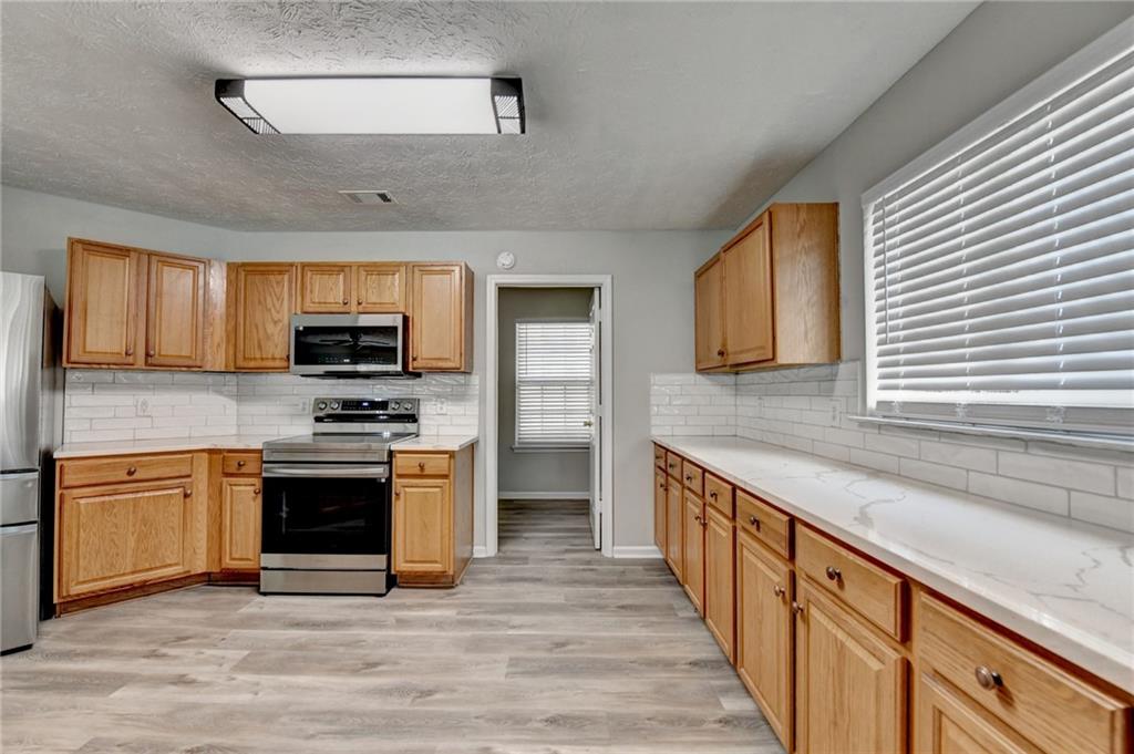2748 Farmstead Court Grayson, GA 30017 - Photo 35 of 83 a kitchen with stainless steel appliances granite countertop a stove a sink and a microwave