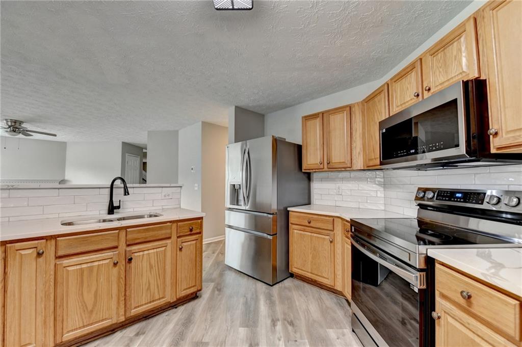 2748 Farmstead Court Grayson, GA 30017 - Photo 38 of 83 a kitchen with a sink stove and refrigerator