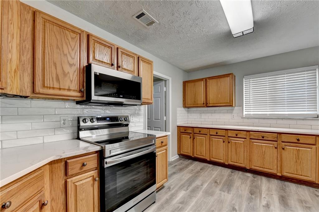 2748 Farmstead Court Grayson, GA 30017 - Photo 40 of 83 a kitchen with stainless steel appliances granite countertop a stove microwave and cabinets
