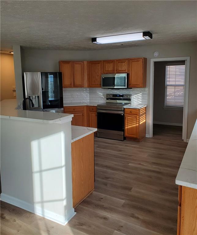 2748 Farmstead Court Grayson, GA 30017 - Photo 83 of 83 a kitchen with stainless steel appliances kitchen island wooden cabinets and granite counter tops