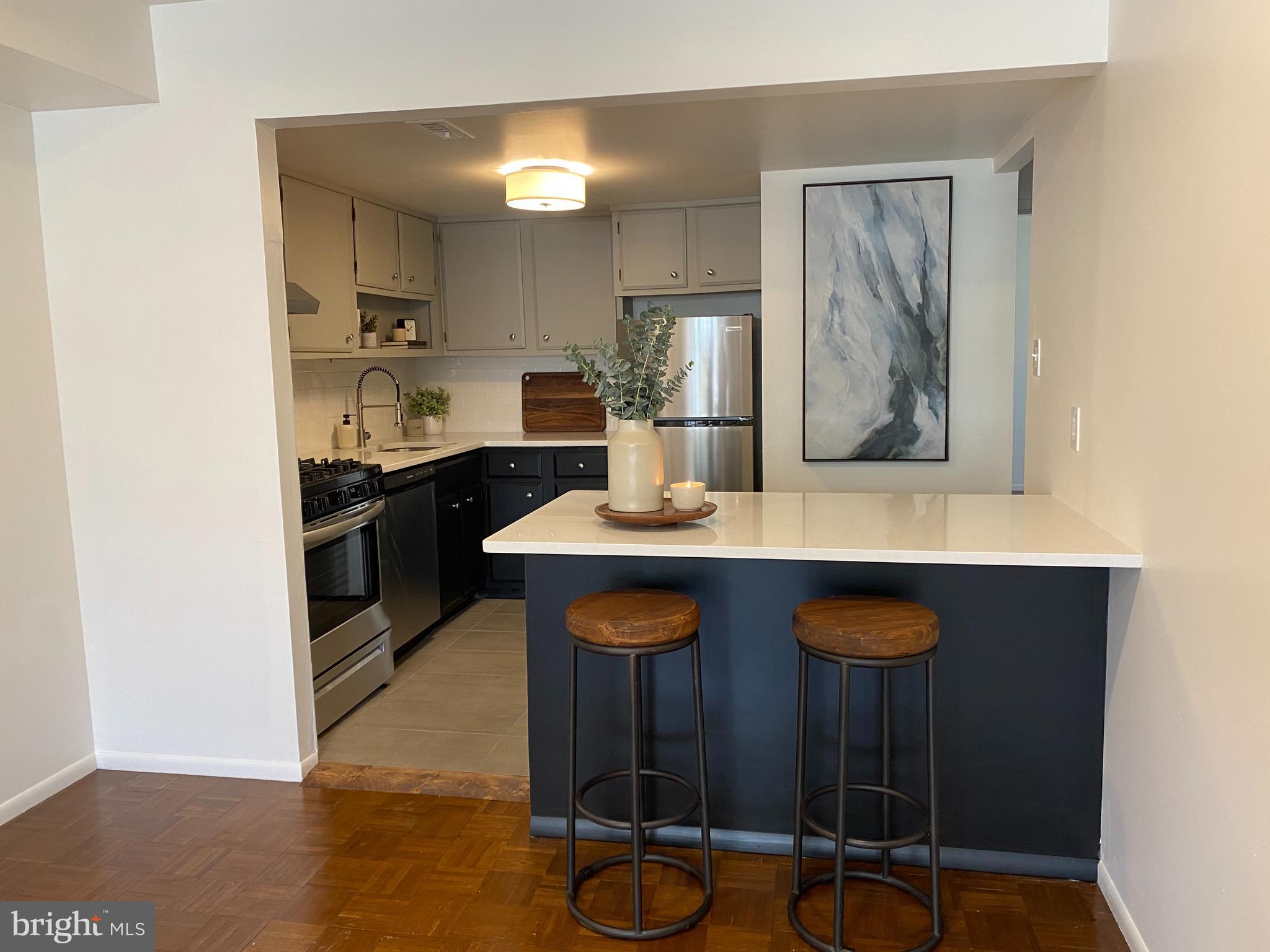 a kitchen with granite countertop a sink cabinets and wooden floor