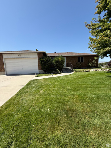 328 Heather Ridge Circle Sandy, UT 84070 - Photo 32 of 32 Brick exterior home featuring a two-car garage, mature landscaping, concrete driveway, and front walkway leading to the entry
