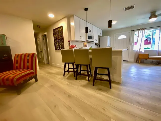 a living room with stainless steel appliances kitchen island furniture and a flat screen tv
