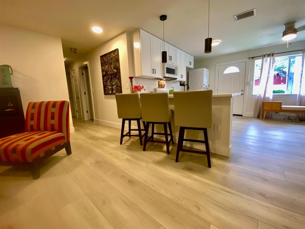 415 Mapleway, Unit A Safety Harbor, FL 34695 - Photo 3 of 50 a living room with stainless steel appliances kitchen island furniture and a flat screen tv