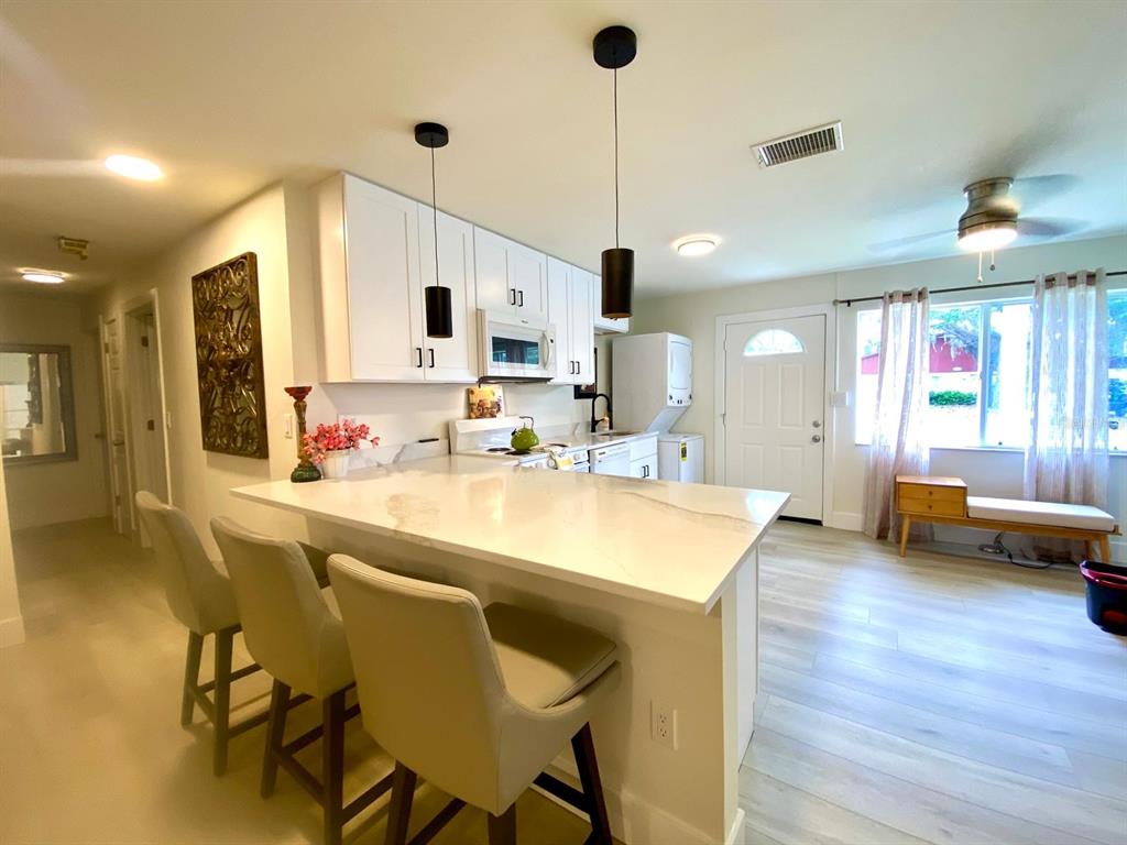 415 Mapleway, Unit A Safety Harbor, FL 34695 - Photo 6 of 50 a kitchen with stainless steel appliances kitchen island granite countertop a sink and chairs