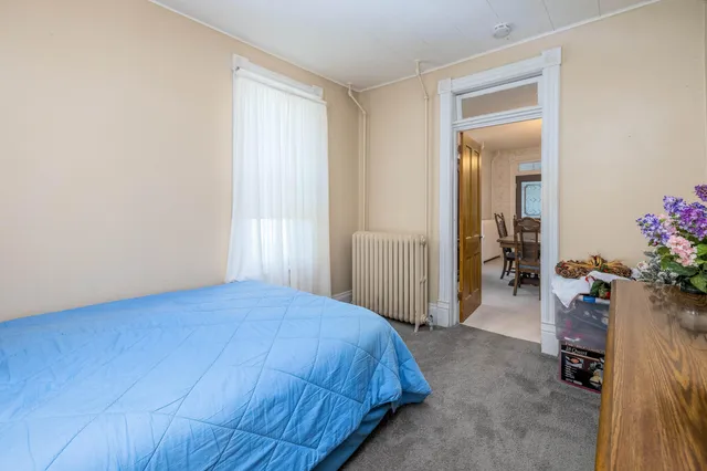 a bedroom with a bed and a large mirror on dresser