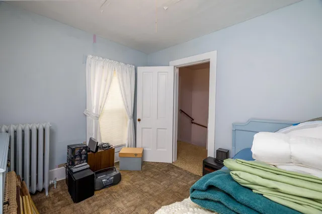 a bedroom with a bed chair and a window