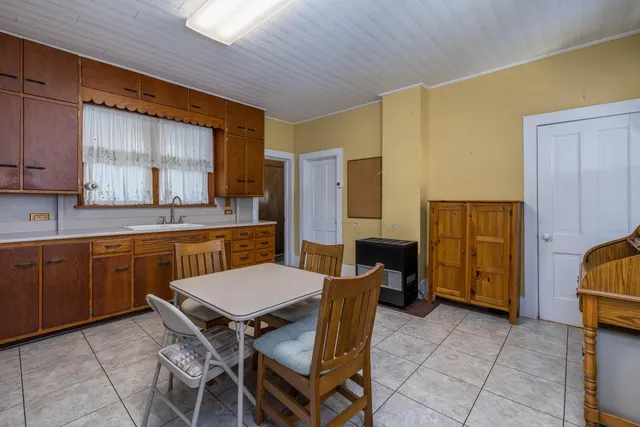 a kitchen with a dining table chairs and refrigerator