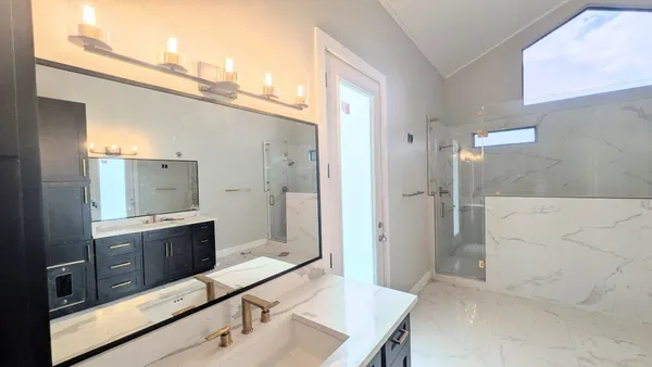 a bathroom with a tub sink shower and mirror