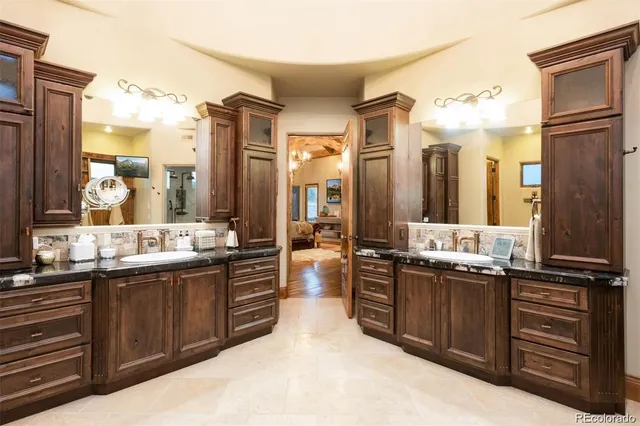a large bathroom with a granite countertop double vanity sink and mirror