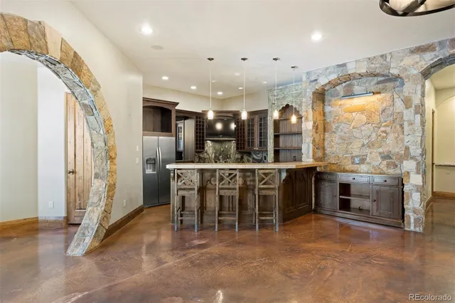 a view of a kitchen with stainless steel appliances kitchen island granite countertop a refrigerator and a sink