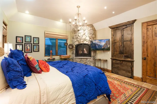 a bed room with a bed mirror and a chandelier