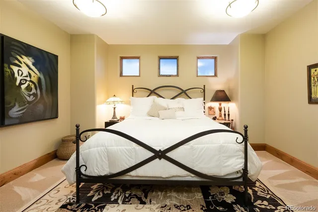 a bedroom with a bed and painting on the wall