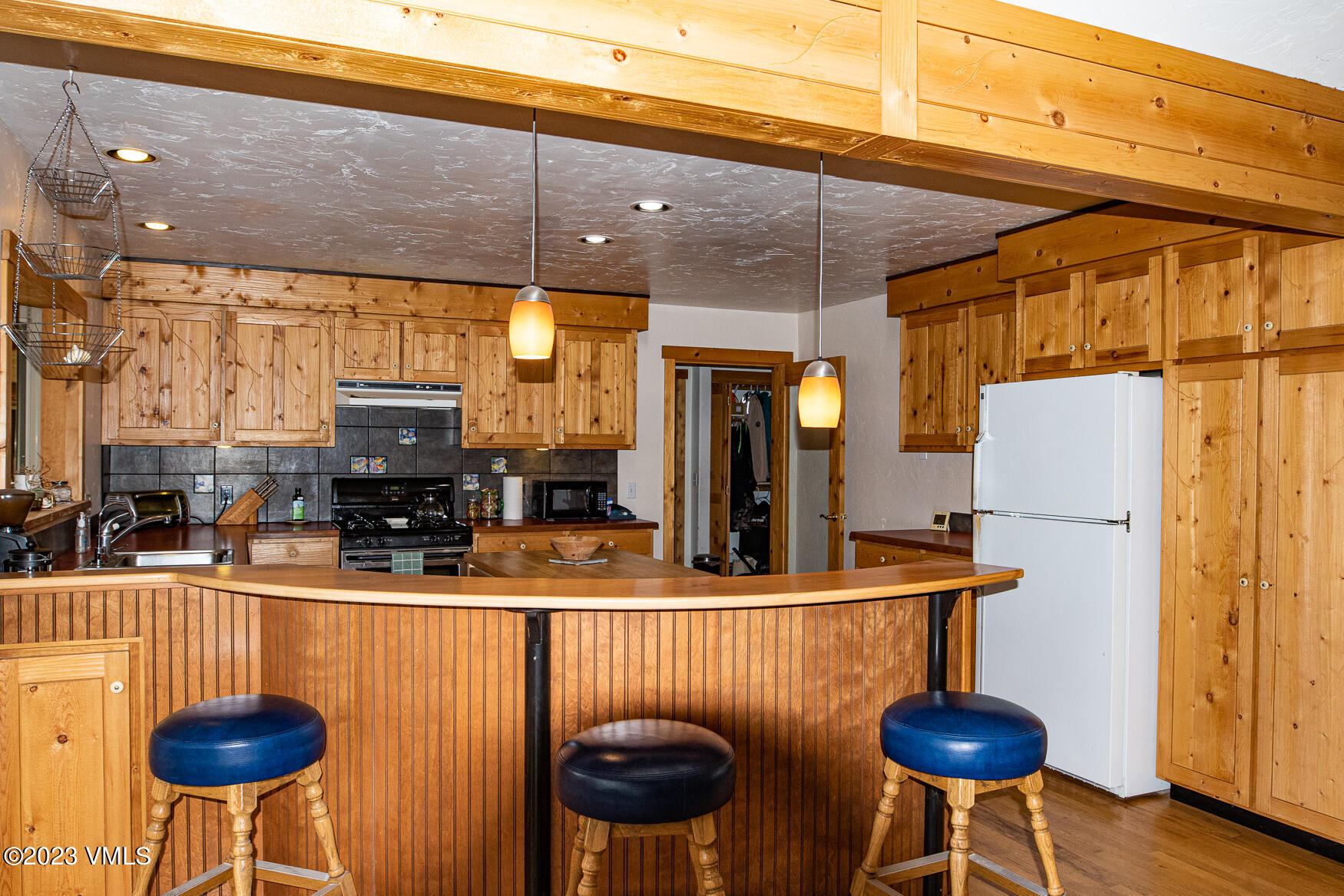 460 Mesa Drive Eagle, CO 81631 - Photo 8 of 42 a kitchen with stainless steel appliances kitchen island granite countertop a table chairs and a refrigerator