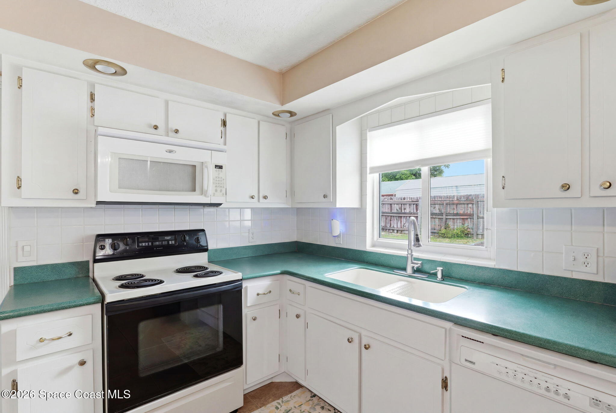 908 Jefferson Road Rockledge, FL 32955 - Photo 14 of 37 a kitchen with granite countertop cabinets stainless steel appliances a sink and a window