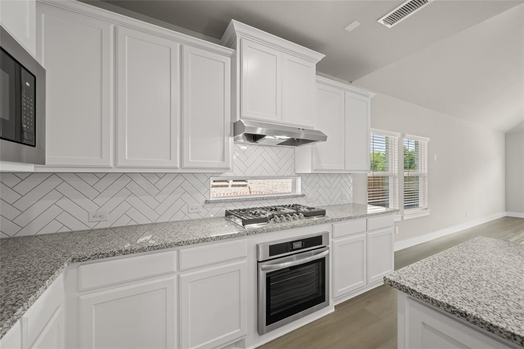 1850 Silver Birch Road Waxahachie, TX 75165 - Photo 12 of 36 a kitchen with granite countertop a sink stove and cabinets