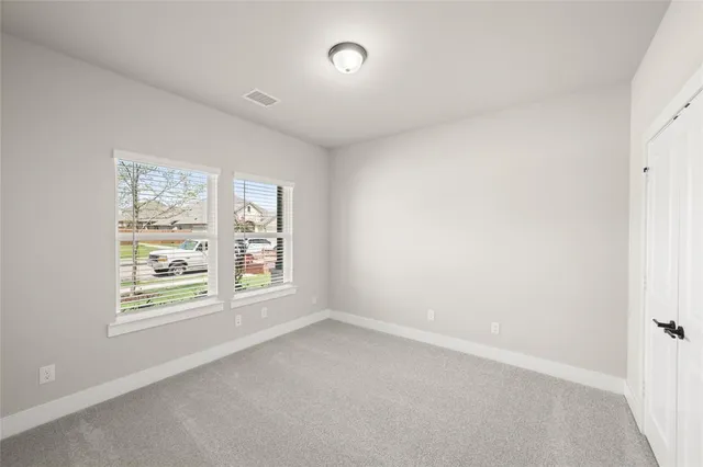 an empty room with closet and a window