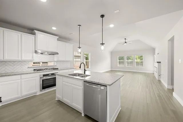 a kitchen with kitchen island a sink stove and refrigerator