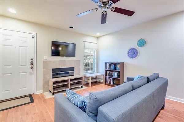 a living room with furniture a fireplace and a flat screen tv