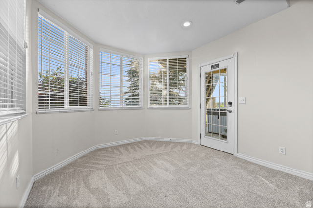 4117 North Wolf Ridge Circle Eden, UT 84310 - Photo 31 of 63 Carpeted room with a bay window design featuring multiple windows with blinds, a recessed ceiling light, and a white door with glass panels
