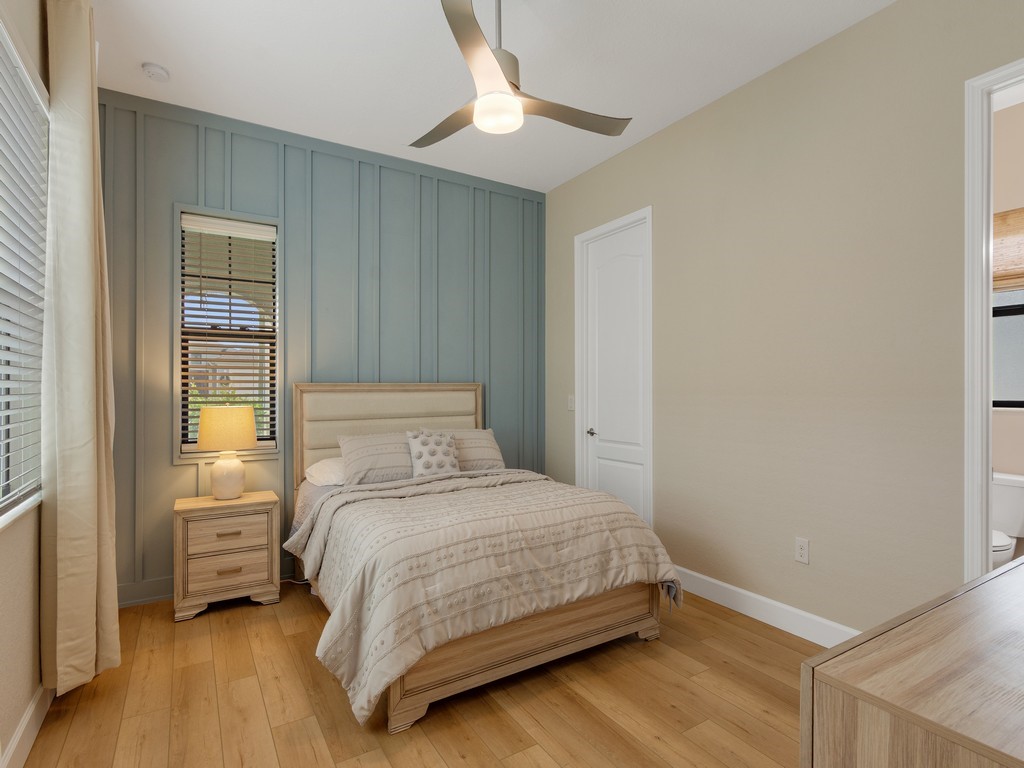 2462 Chapel Bridge Lane Melbourne, FL 32940 - Photo 17 of 36 a bedroom with a bed and a chandelier