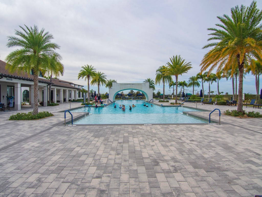 2462 Chapel Bridge Lane Melbourne, FL 32940 - Photo 31 of 36 a view of a swimming pool with a yard and palm trees
