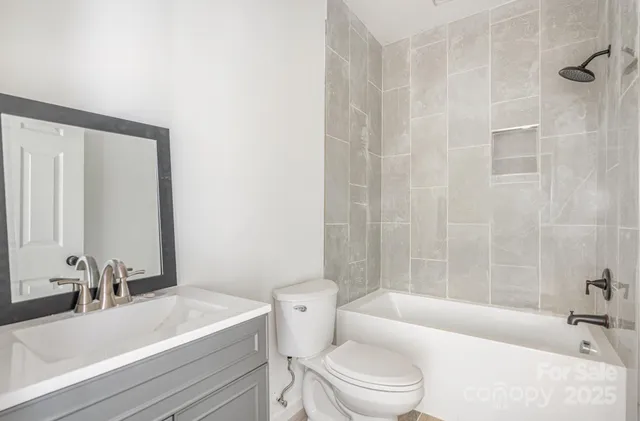 a bathroom with a sink toilet vanity and shower