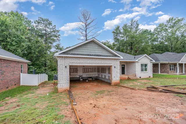a view of a house with a yard and large tree
