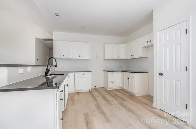 a kitchen with granite countertop a sink and a stove top oven