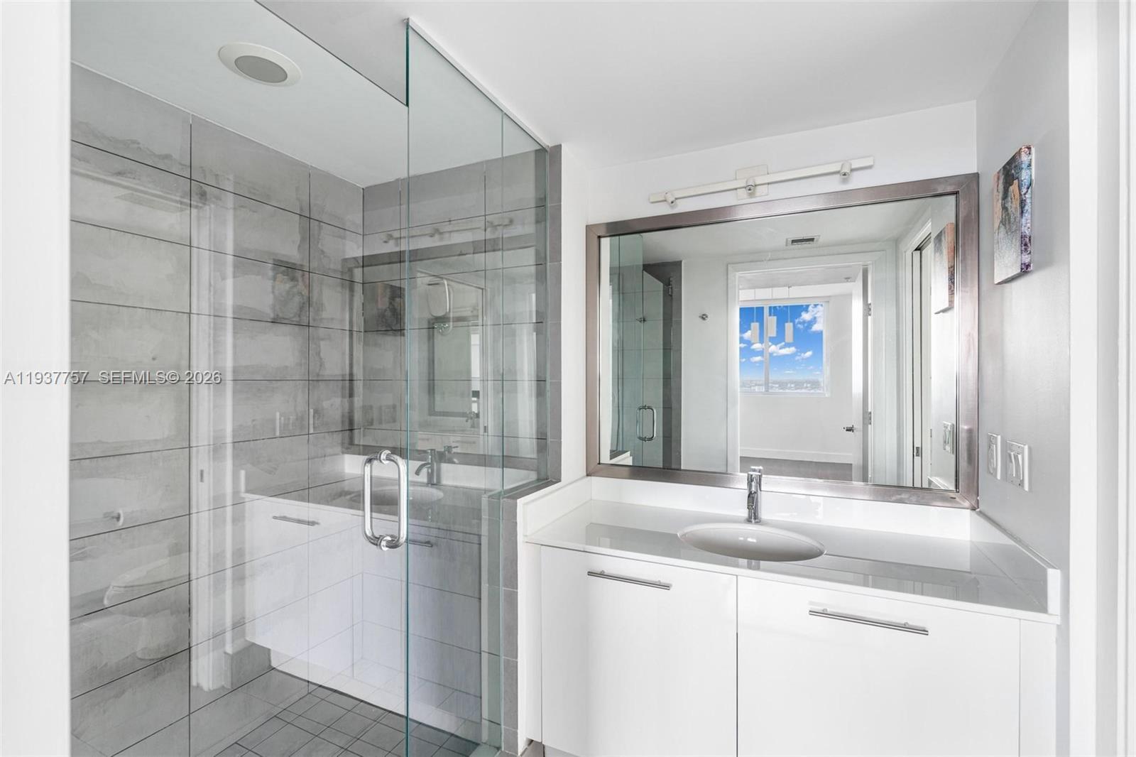 92 Southwest 3rd Street, Unit 4109 Miami, FL 33130 - Photo 6 of 23 a bathroom with a double vanity sink mirror and shower