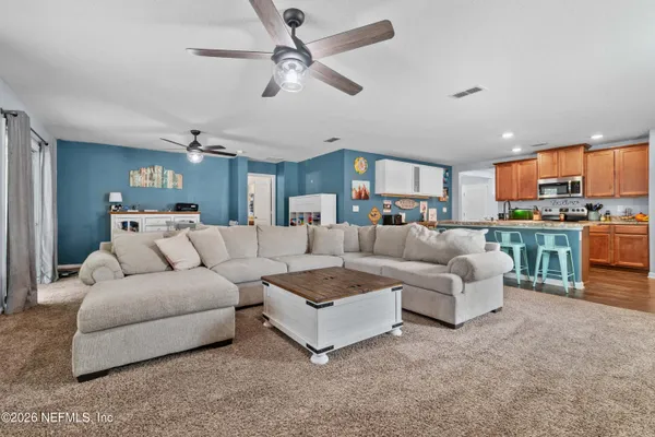 a living room with furniture and a view of kitchen