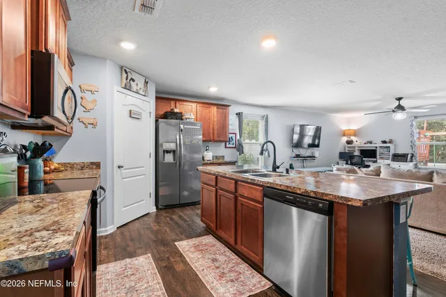 a kitchen with stainless steel appliances granite countertop a sink stove and refrigerator