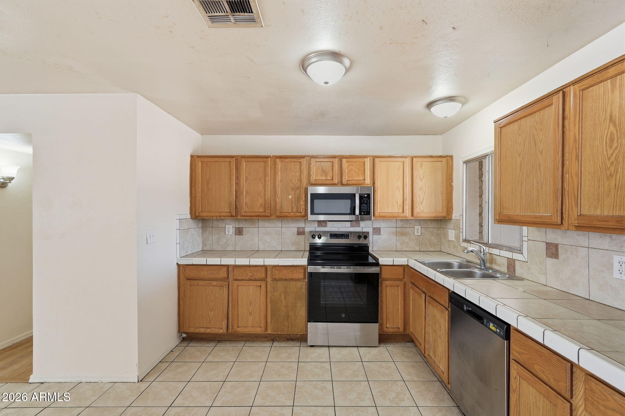 6452 West Thomas Road Phoenix, AZ 85033 - Photo 10 of 30 a kitchen with a sink white cabinets and stainless steel appliances