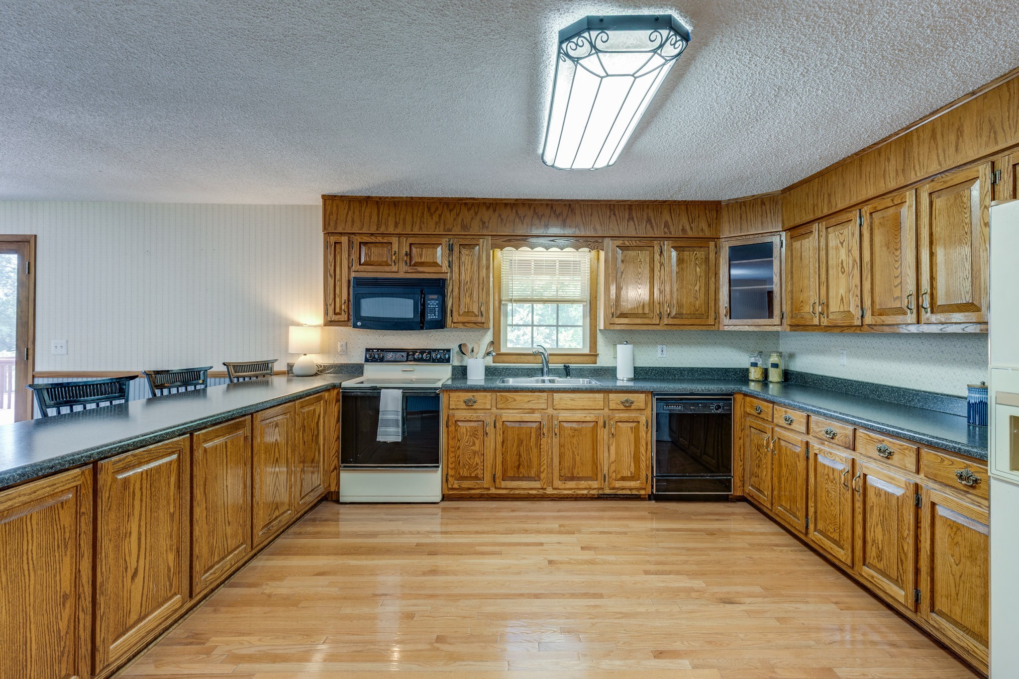 1087 Charley Davis Road Goodspring, TN 38460 - Photo 16 of 80 a large kitchen with stainless steel appliances granite countertop a stove top oven a sink dishwasher a dining table and chairs with wooden floor
