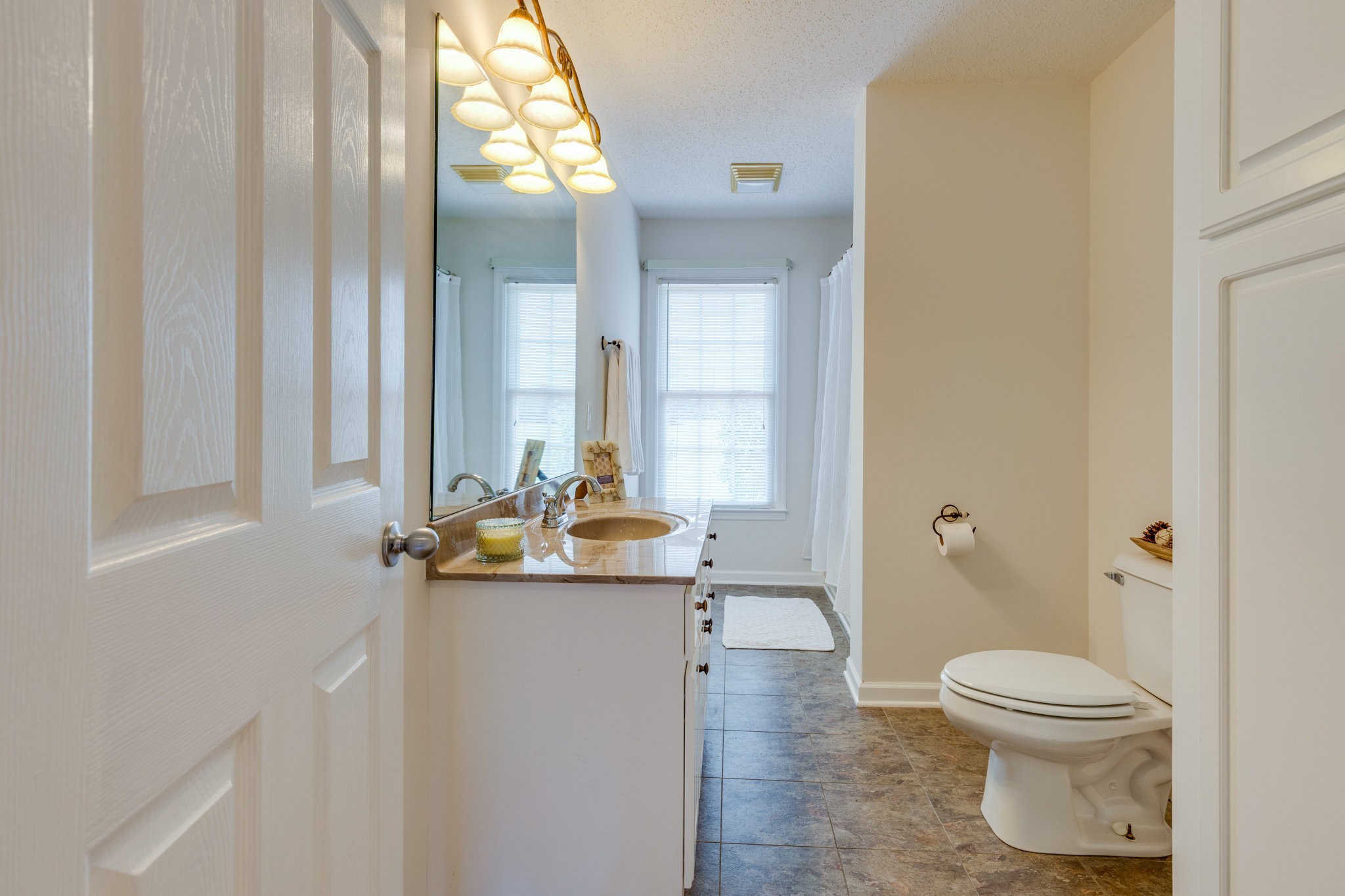 1087 Charley Davis Road Goodspring, TN 38460 - Photo 37 of 80 a bathroom with a granite countertop sink a toilet and a mirror