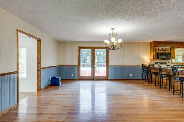 a dining room with furniture a chandelier and wooden floor