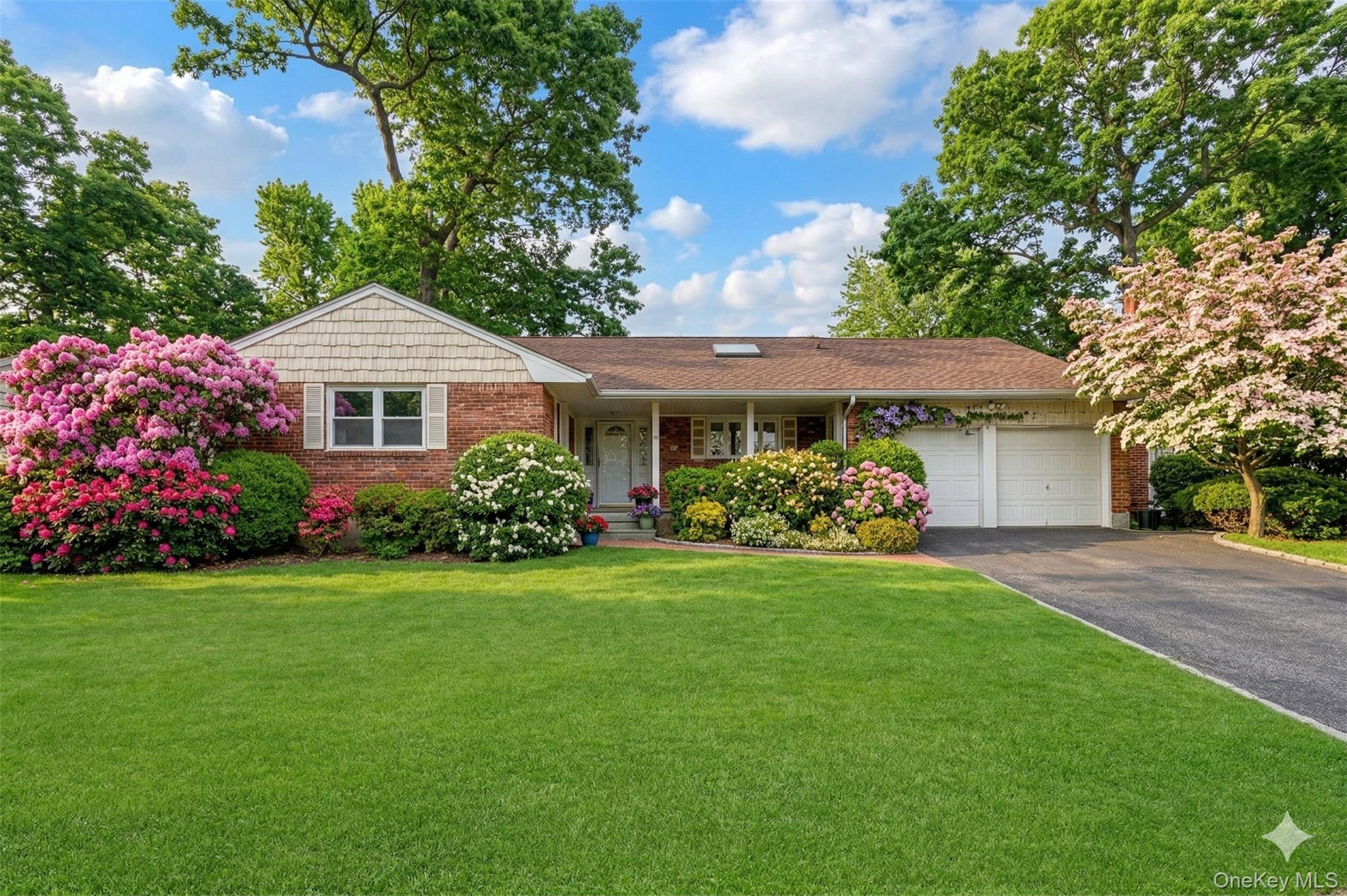27 Cedar Street Syosset, NY 11791 - Photo 1 of 28 a front view of a house with a garden