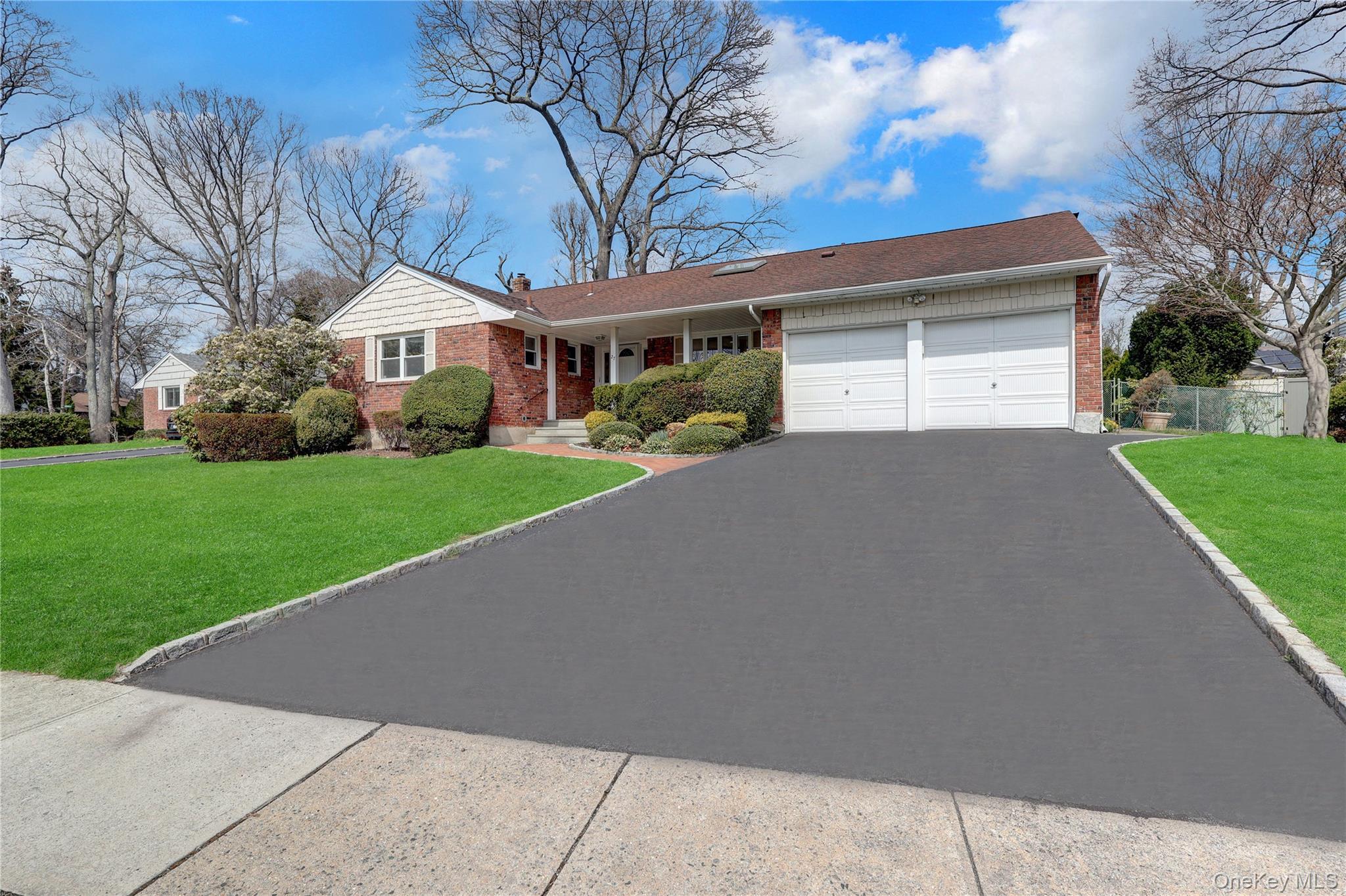 27 Cedar Street Syosset, NY 11791 - Photo 2 of 28 a front view of a house with a yard and garage