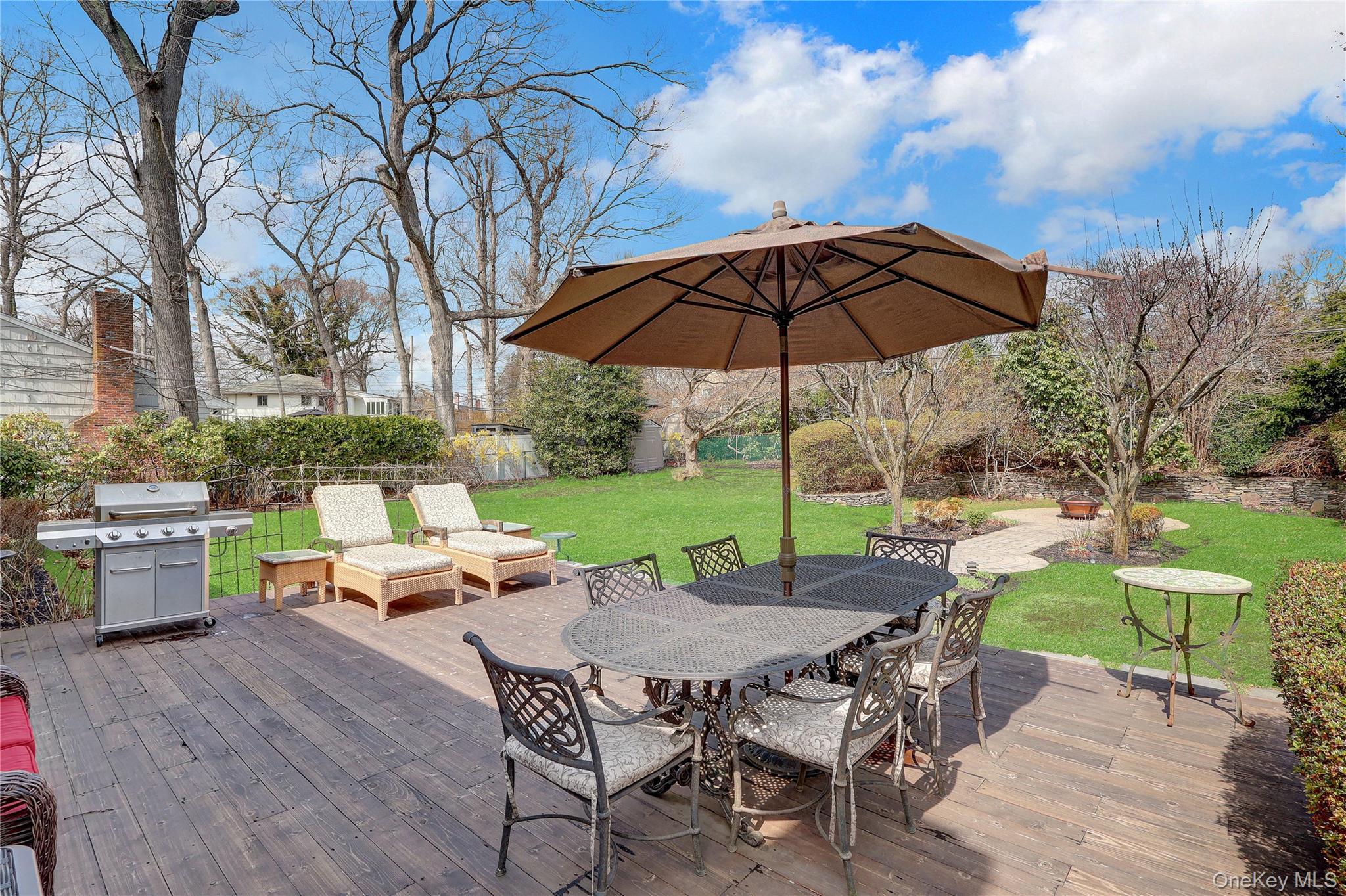27 Cedar Street Syosset, NY 11791 - Photo 21 of 28 a view of a patio with a table chairs and a yard