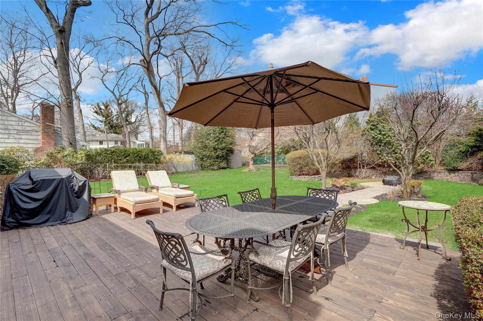 27 Cedar Street Syosset, NY 11791 - Photo 28 of 28 a view of a table and chairs under an umbrella