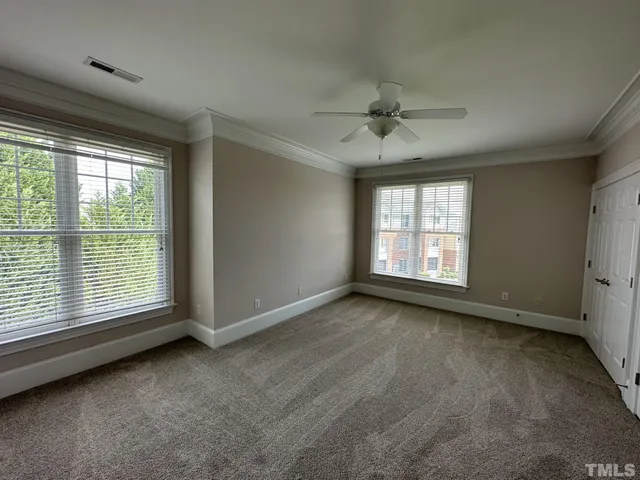 an empty room with a window and a fan
