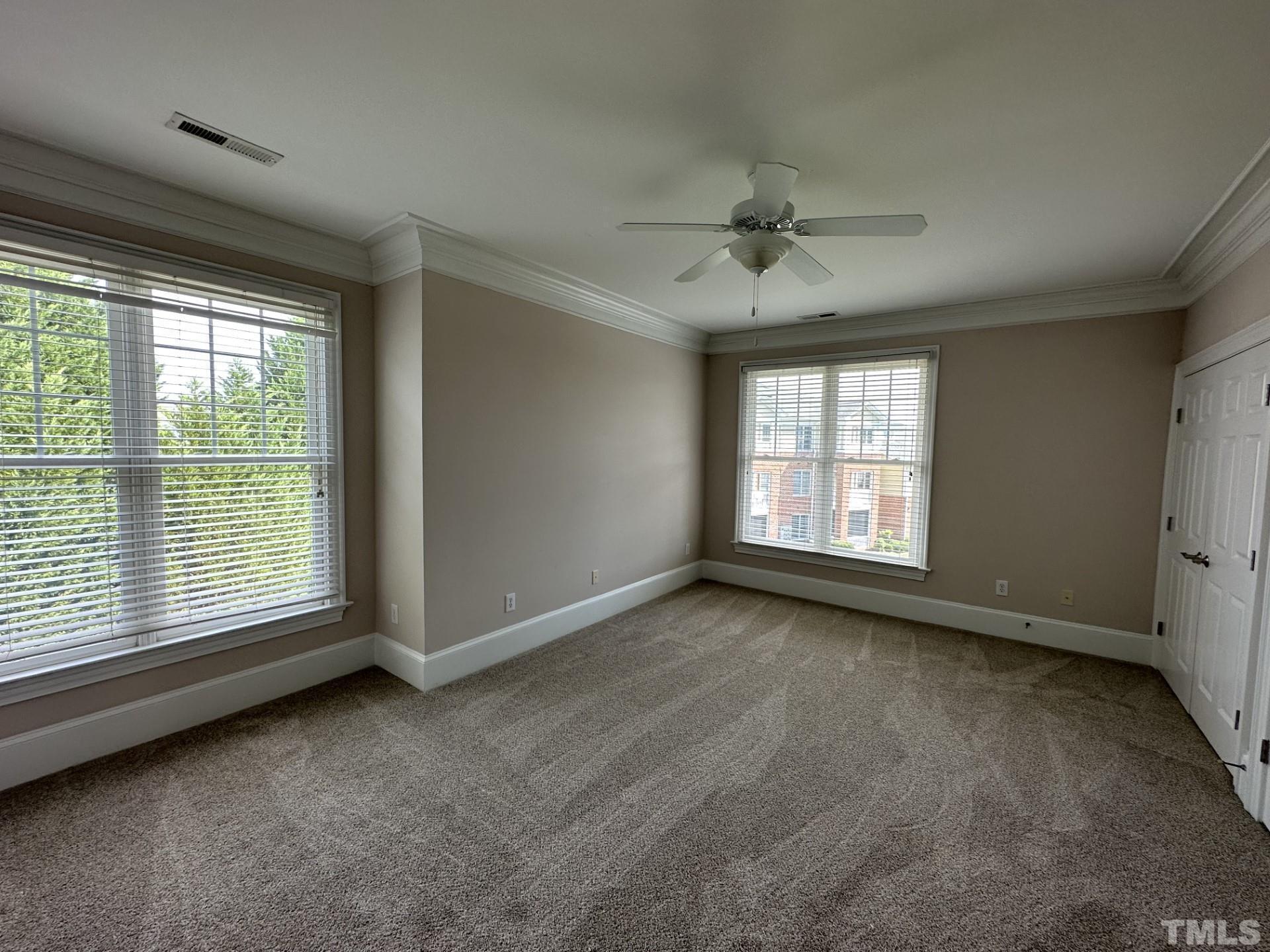 623 Waterford Lake Drive, Unit 623 Cary, NC 27519 - Photo 13 of 18 an empty room with chandelier fan and windows