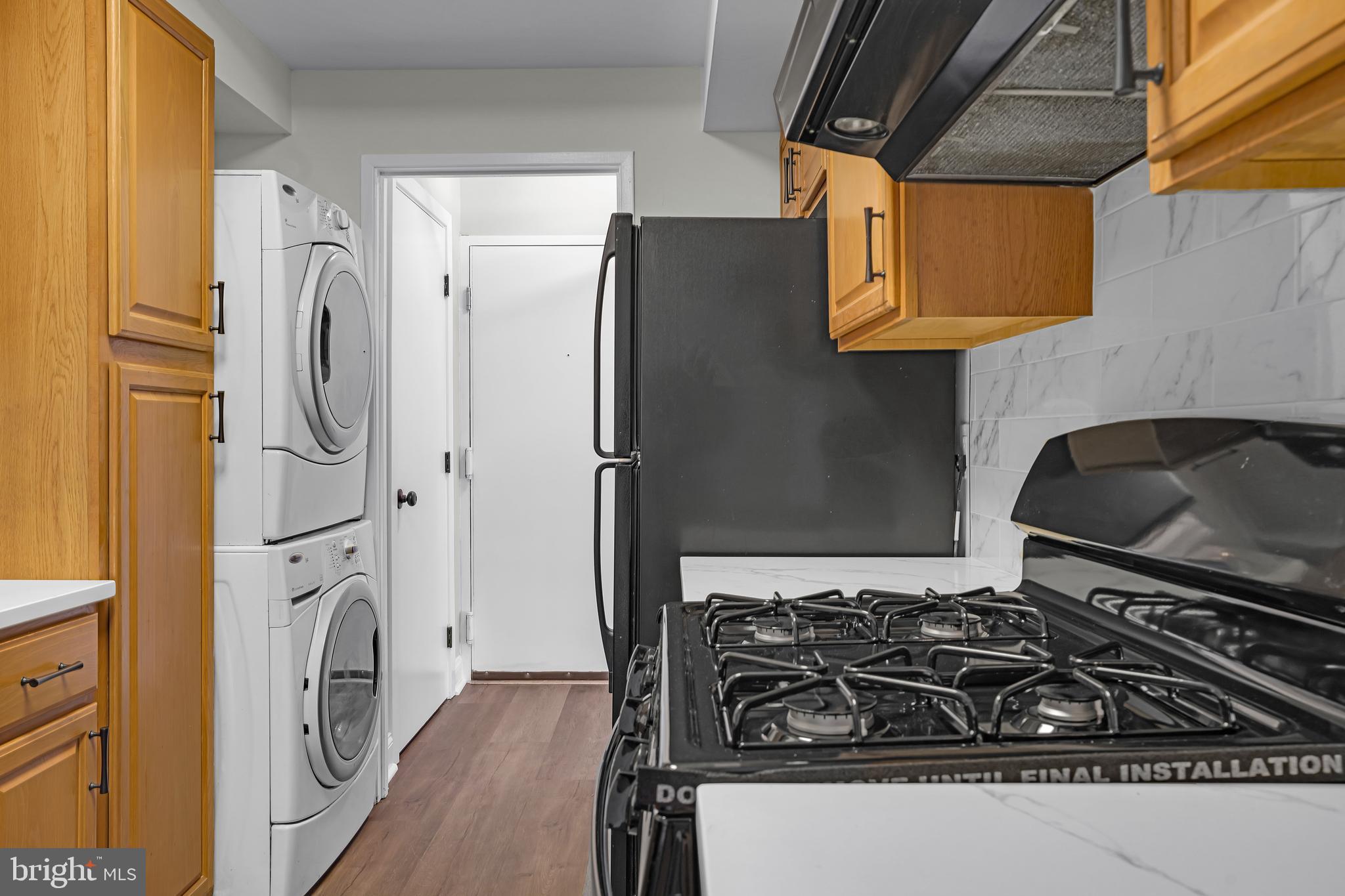 10239 Prince Place, Unit 26103 Upper Marlboro, MD 20774 - Photo 11 of 25 a kitchen with stainless steel appliances granite countertop a stove and a refrigerator