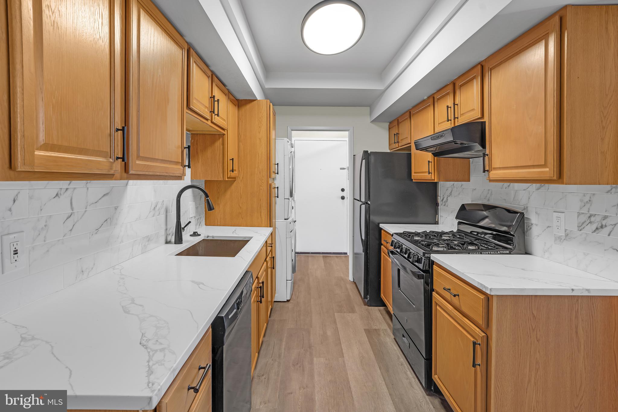 10239 Prince Place, Unit 26103 Upper Marlboro, MD 20774 - Photo 12 of 25 a kitchen with stainless steel appliances granite countertop a sink a stove and a refrigerator