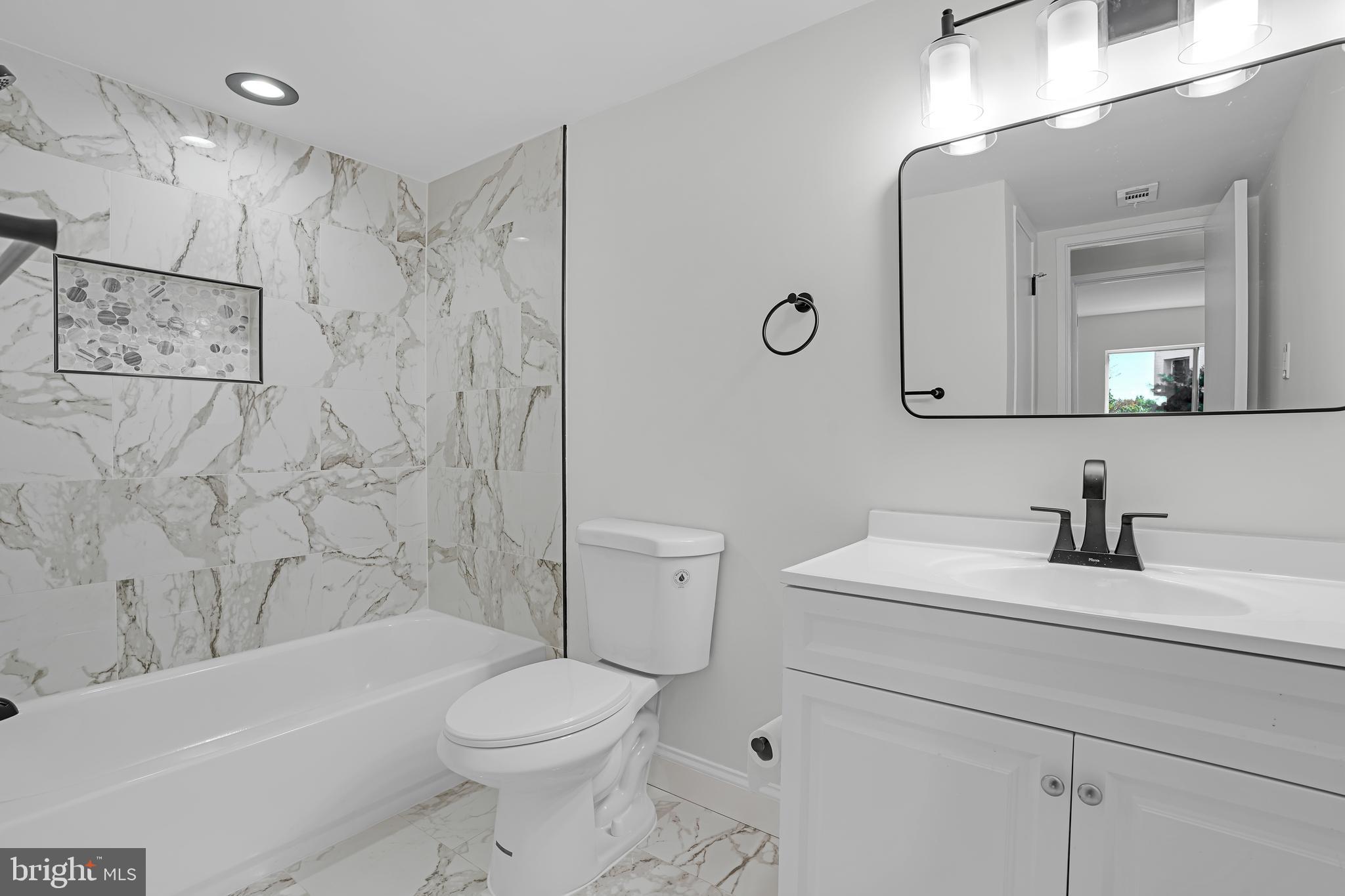 10239 Prince Place, Unit 26103 Upper Marlboro, MD 20774 - Photo 20 of 25 a bathroom with a sink a toilet and a bathtub